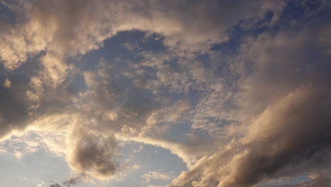 Clouds-lit-by-late-afternoon-sunlight-move-through-sky-in-time-lapsed-motion