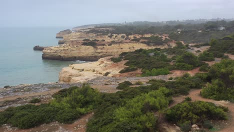 fontainhas beach cliffs in south portugal seen from the side, aerial dolly in reveal shot