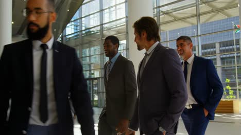 mixed-race business people walking together in the lobby at office 4k