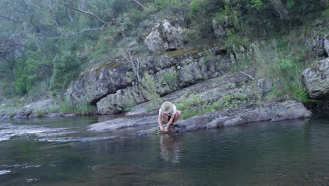 Ein-Buschmann-Säubert-Eine-Frisch-Gefangene-Forelle,-Die-In-Einem-Fluss-Im-Australischen-Busch-Gefangen-Wurde