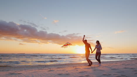 pareja joven jugando con una cometa en la playa al atardecer prores hq video de 10 bits