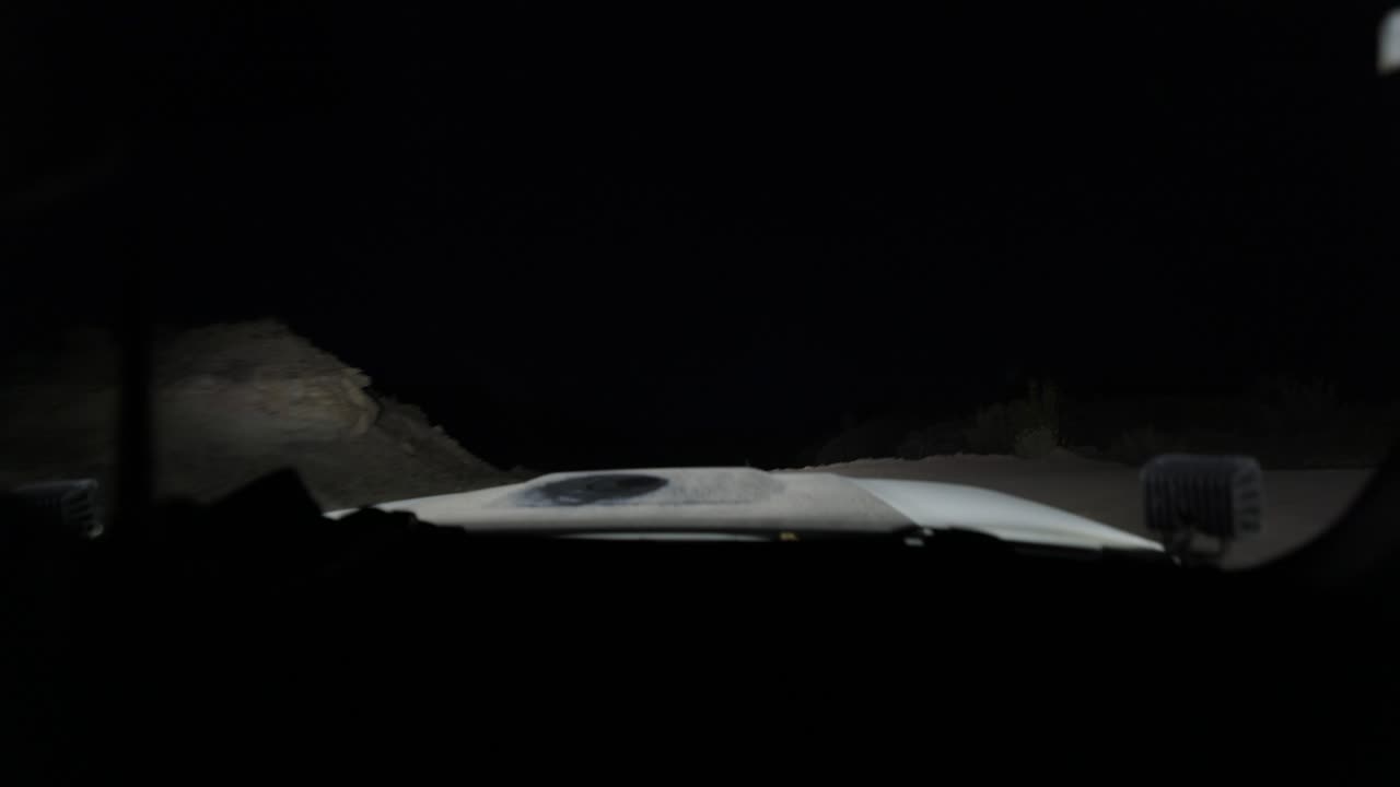 밤중에 사막을 가로질러 이동하는 트럭의 운전자의 흔들리는 휴대용 영상