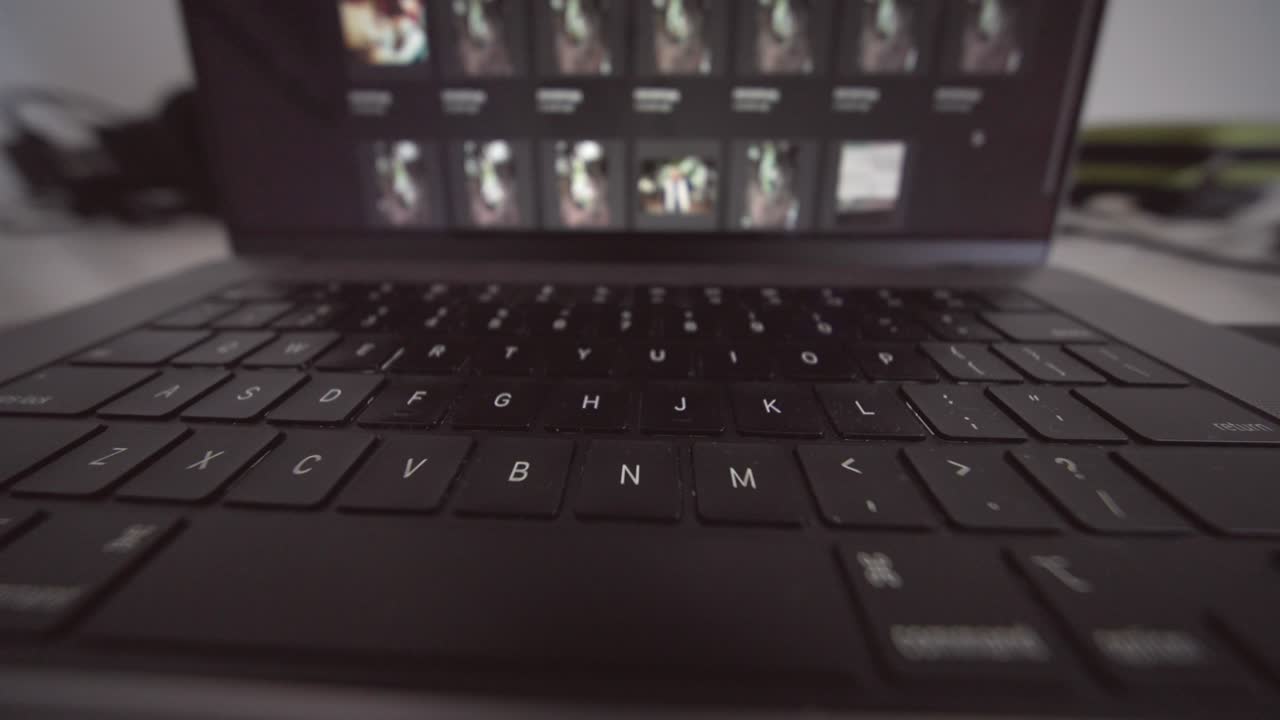 Close Up of Laptop Keyboard with Screen Displaying Thumbnails