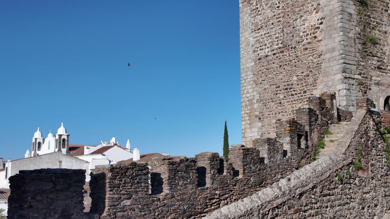 Monsaraz Castle, a medieval fortress, rises against a clear blue sky in the picturesque Alentejo region of Portugal