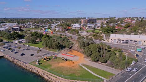 las excavadoras de construcción excavan tierra en la orilla del río swan cerca de la escultura containbow de fremantle, perth, australia occidental