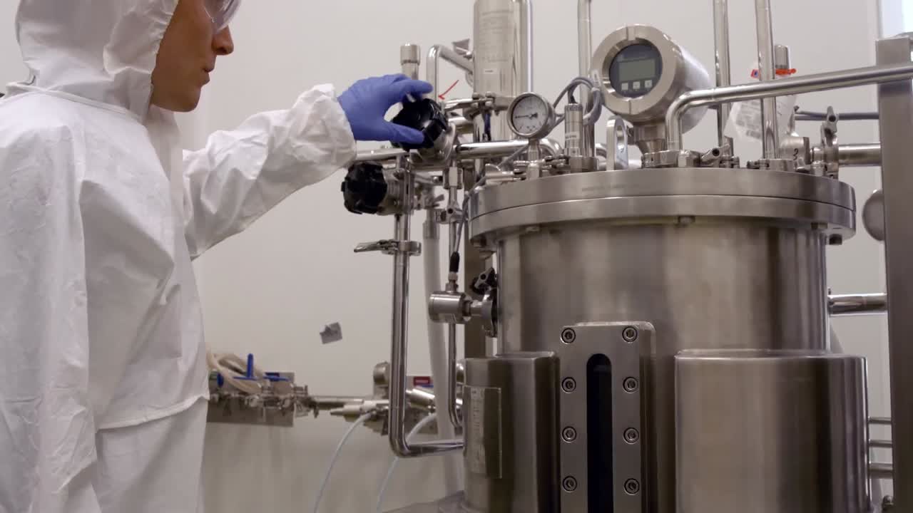 científico en trajes de protección trabajando en el tanque