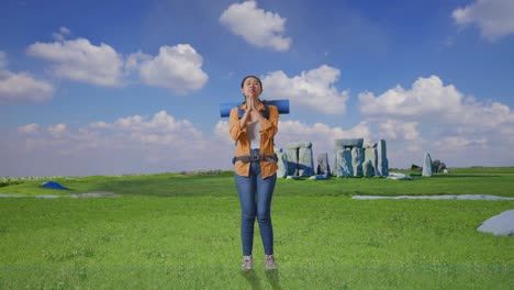 full body of asian female hiker with mountaineering backpack pray for something while traveling in stonehenge