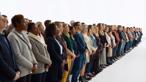 a diverse group of people standing in a long line on a white background