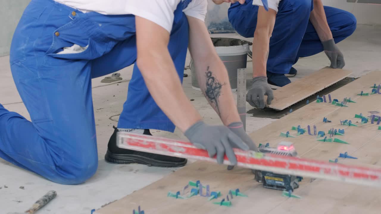Installing ceramic floor tiles - measuring and cutting the pieces. Construction, renovation, repair apartment. Cuts tile. Tile cutting