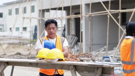 civil engineers prepares to work with team on building site while wearing a safety helmet on his head.