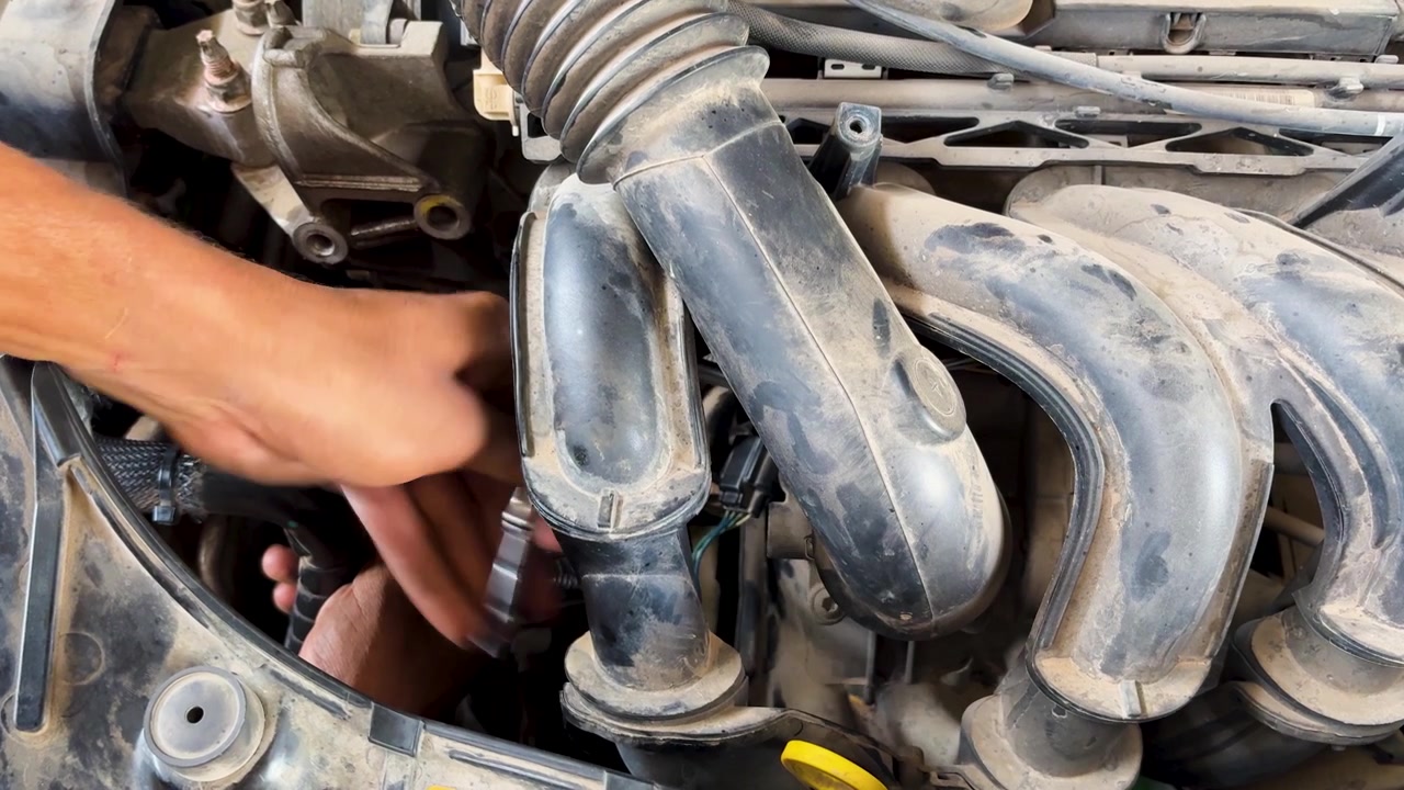 automotive technician servicing engine bay during scheduled vehicle maintenance and inspection