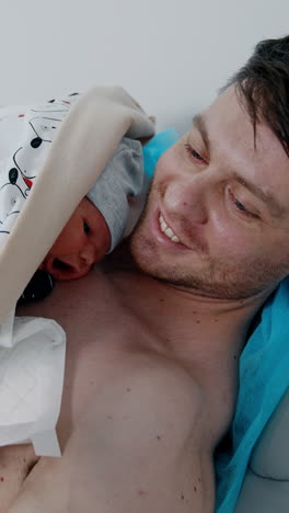 father holding newborn baby in hospital
