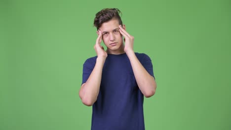 young handsome teenage boy having headache