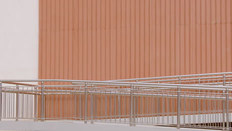 young american man in formal clothes going to work on bicycle and passing in front of a prefab metal building 1