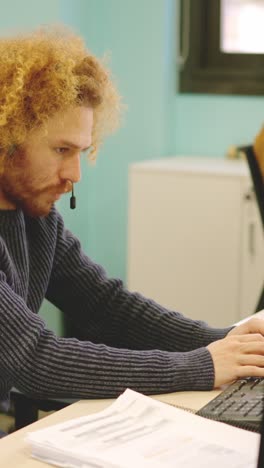 modern man working in a coworking using computer and headset