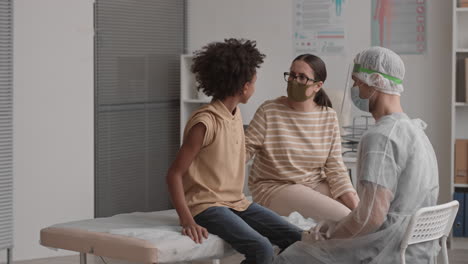 mother reassuring boy getting vaccine shot