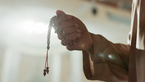 muslim, prayer beads and hand of man in mosque