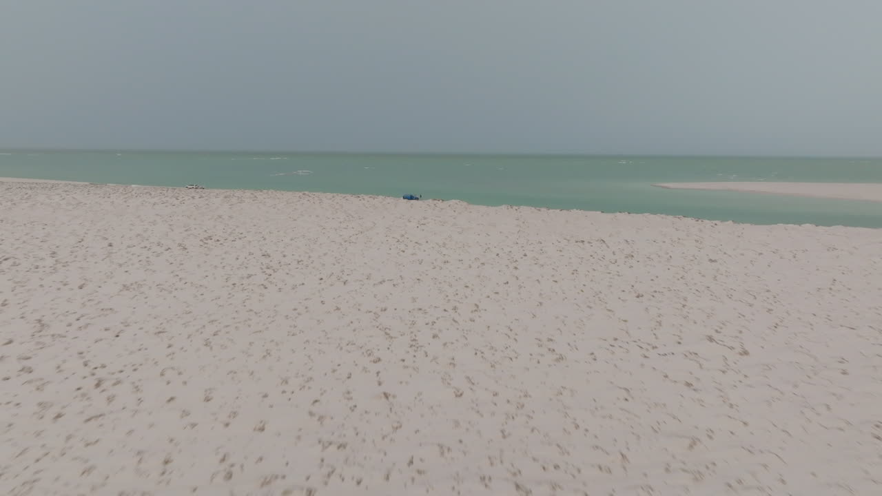 Deserted beach in Oman with turquoise water and clear skies, peaceful and serene atmosphere