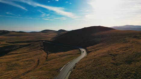 aerial view of prahova valley mountains romania with car driving on scenic narrowed road during a sunny day of summer , vacation lifestyle concept