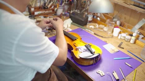 craftsman assembling bow on violin