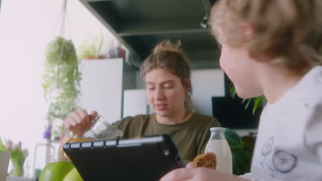 little boy chatting with lesbian parents on breakfast