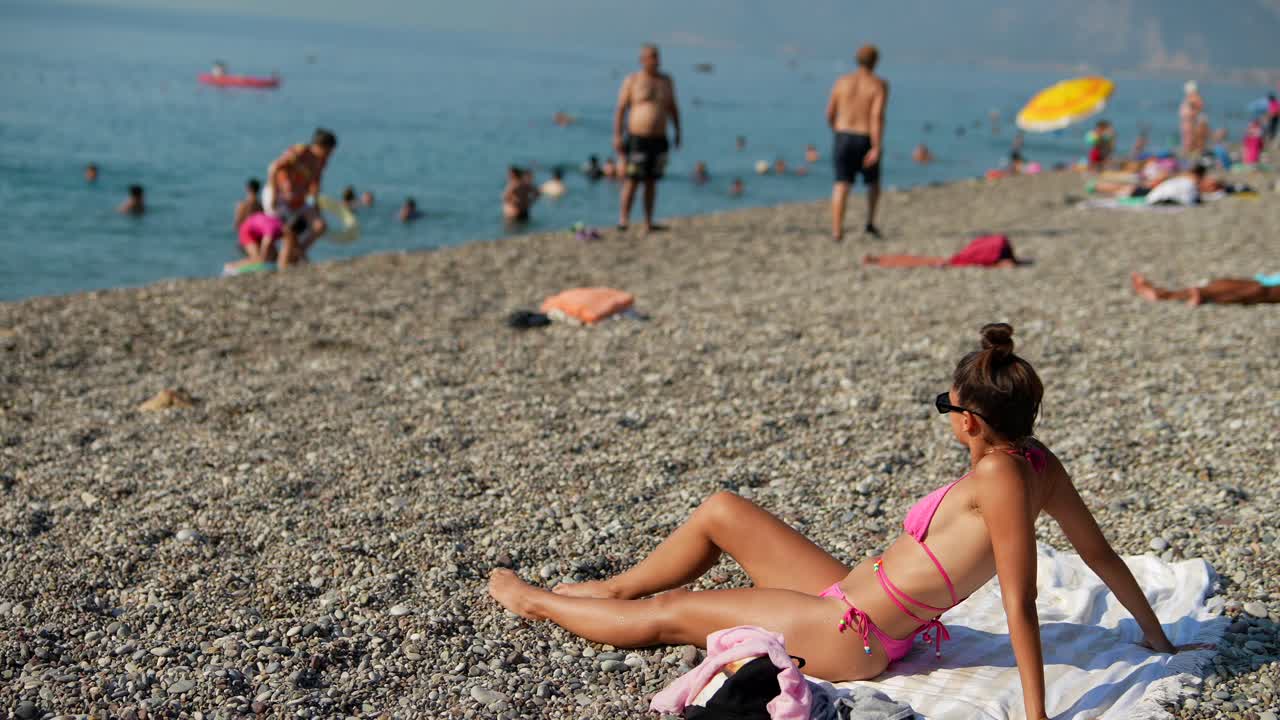 mujer tomando el sol en una playa de guijarros