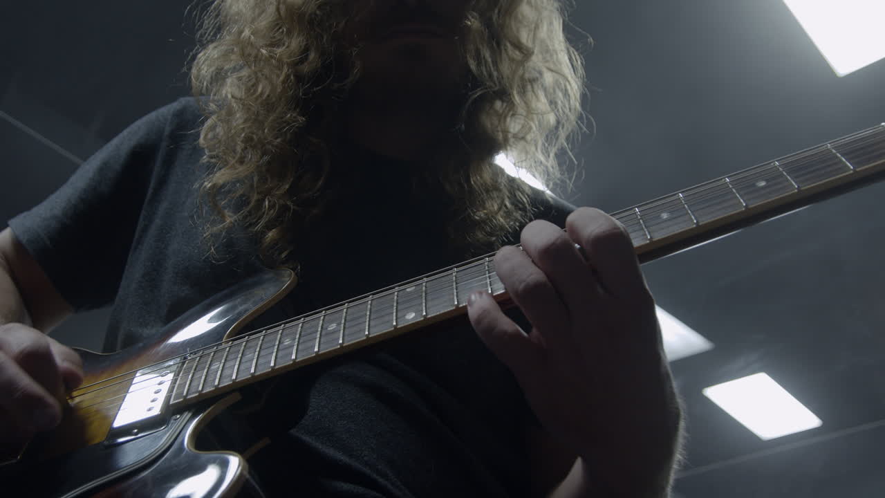Stylischer Rockmusiker spielt E-Gitarre