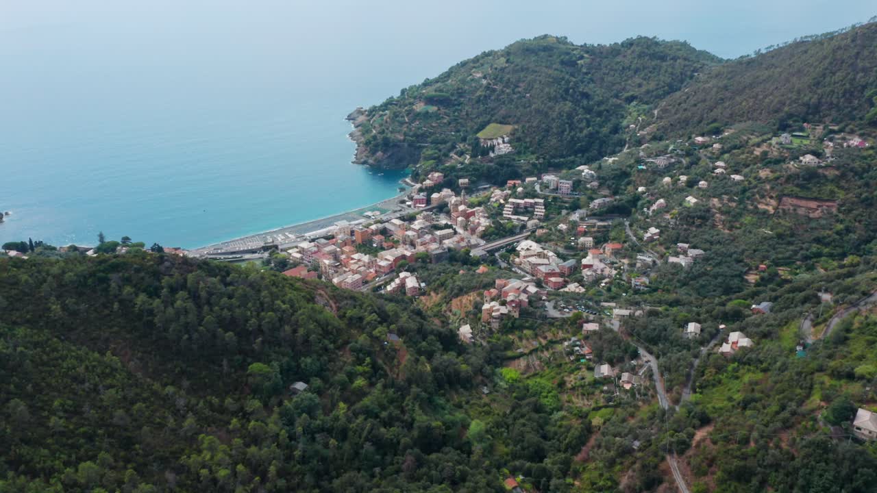 Sunny coastal town in valley, drone aerial panorama