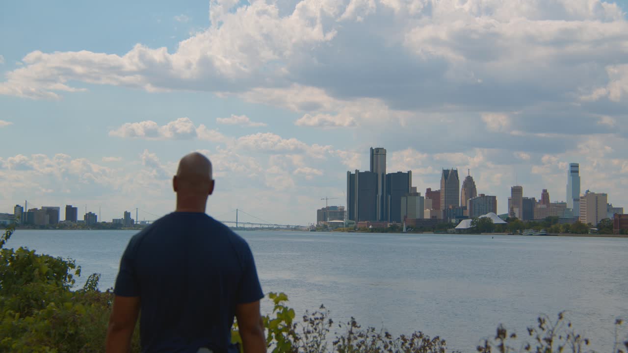 Black male taking in view of downtown Detroit and the Detroit River
