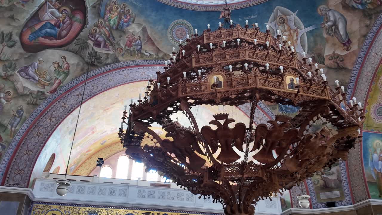 Patras,Interior of Saint Andrew's Church,Footage starts with Virgin Marry's fresco than passing through the golden chandelier surrounded by colorful fresco's during day time