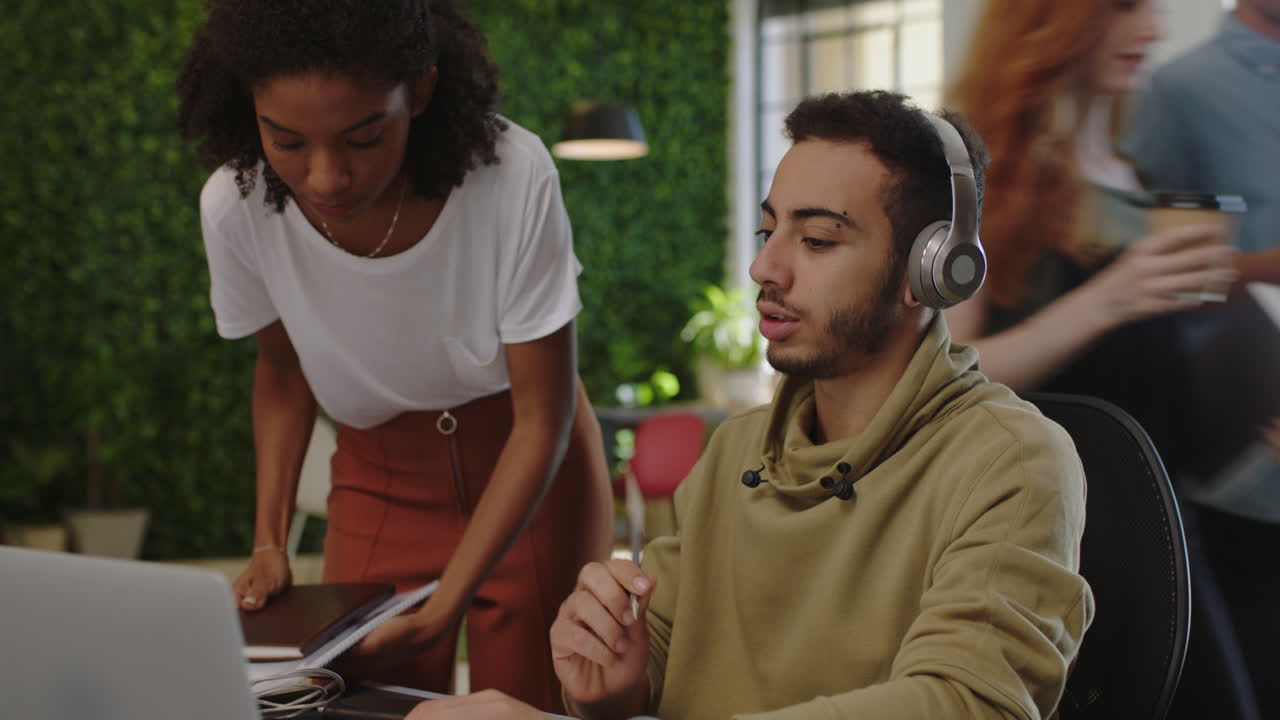 jóvenes empresarios diversos se reúnen líder de equipo mujer mostrando estudiante colega proyecto de investigación en la pantalla de la computadora portátil compartiendo ideas creativas en el ajetreado lugar de trabajo de la oficina