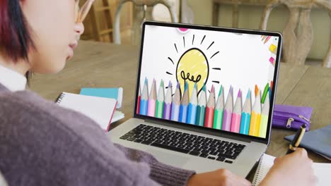 asian female student having class on laptop video call with pencils and lightbulb in slow motion