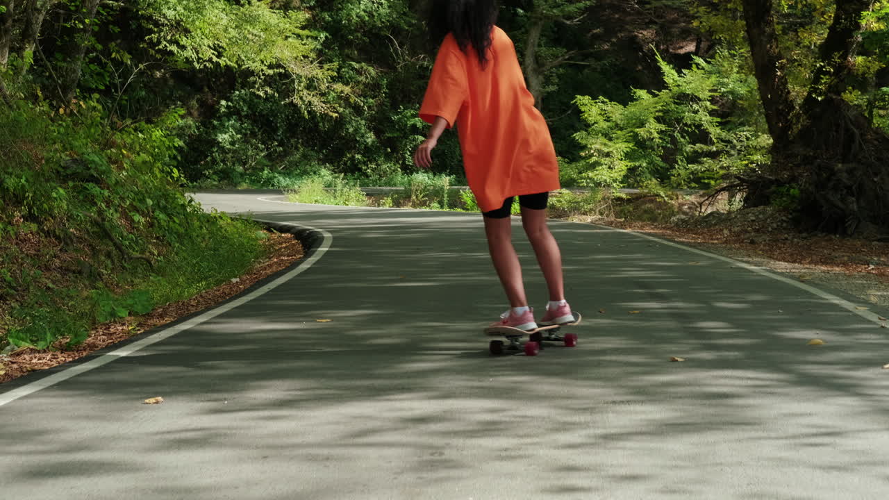 숲에서 스케이트보드를 타는 여자
