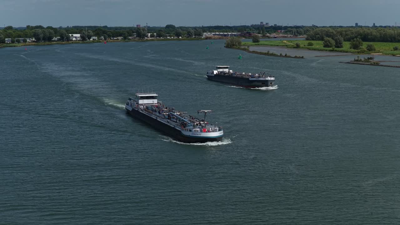 Company Barendrecht cargo ships moving along river channel with countryside environment, Zuid-Holland, Netherlands