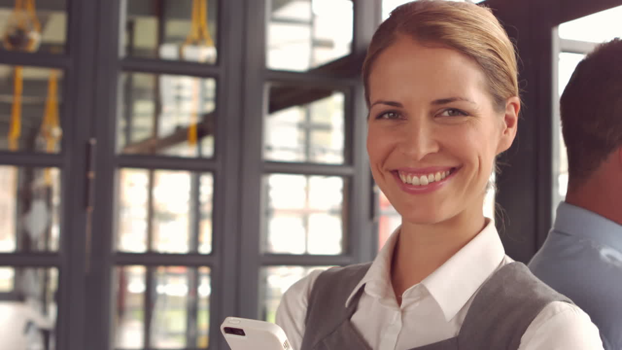 Smilende forretningskvinne som bruker smarttelefon