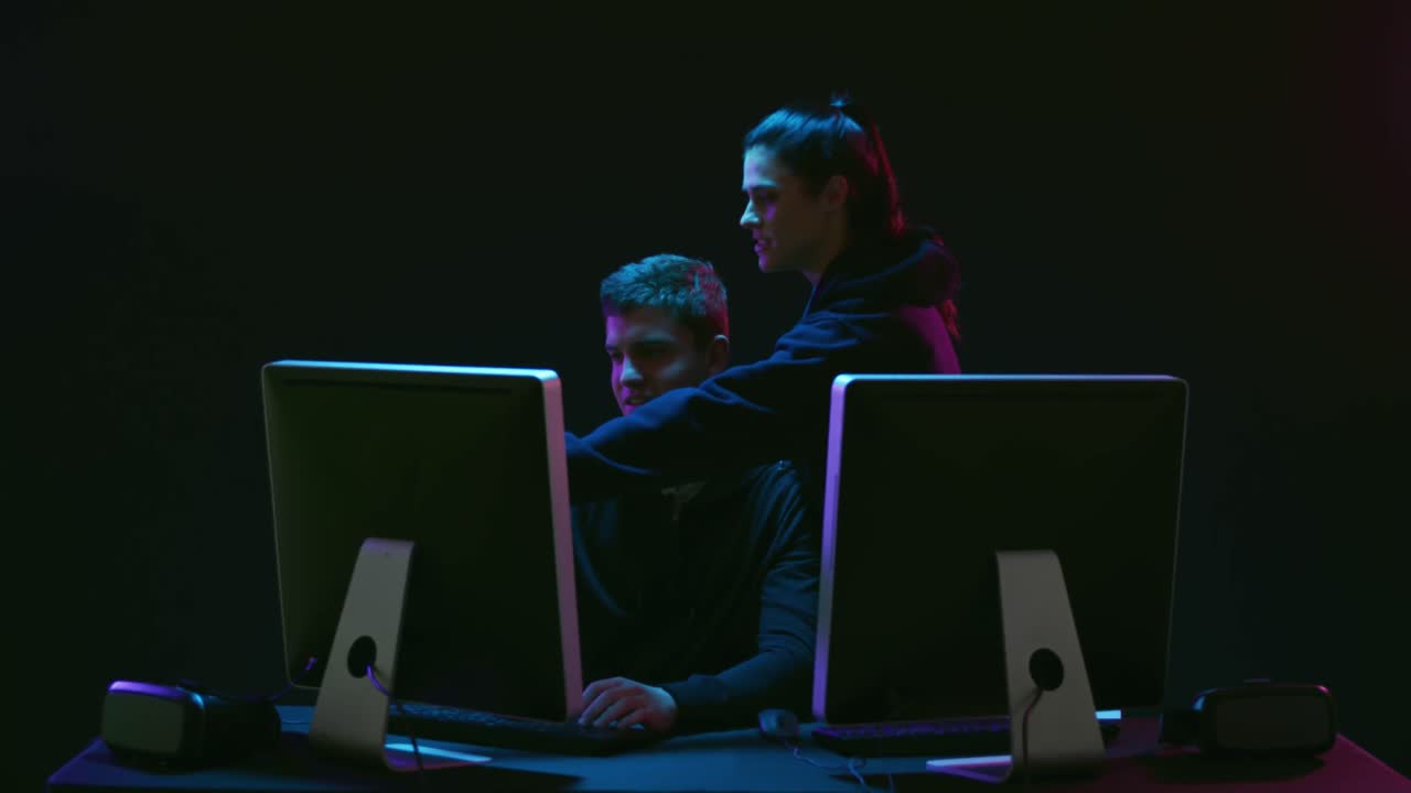 hombre y mujer trabajando en computadoras