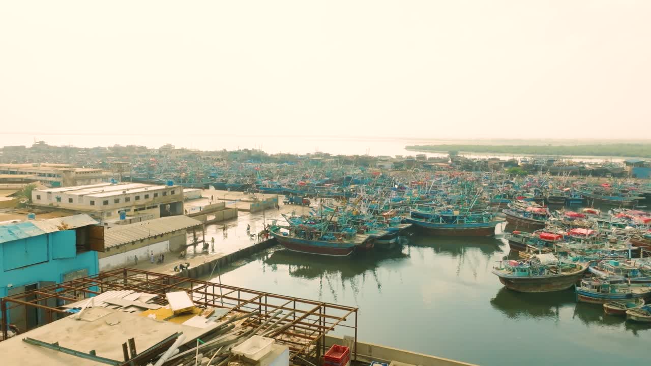 Dozens of Fishing Boats Docked in a Busy Harbor in Karachi City
