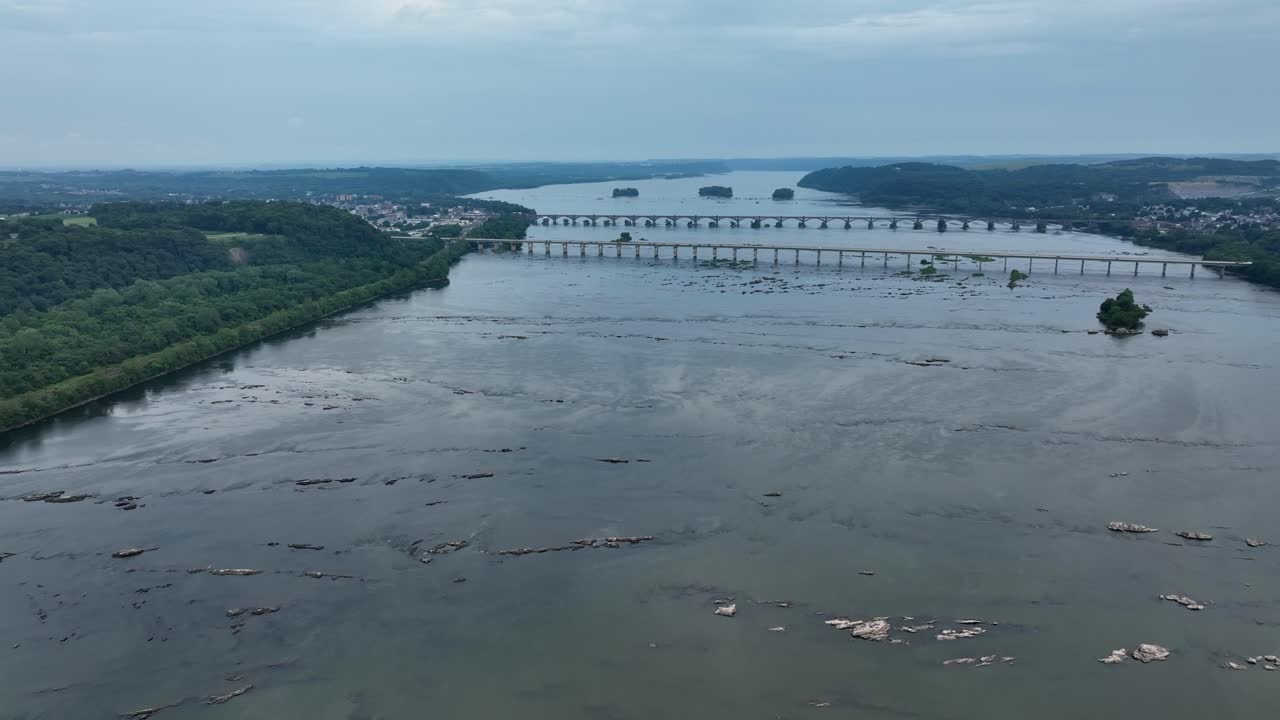 una vista aérea del río susquehanna mientras fluye a través de pennsylvania con los puentes de columbia en el fondo