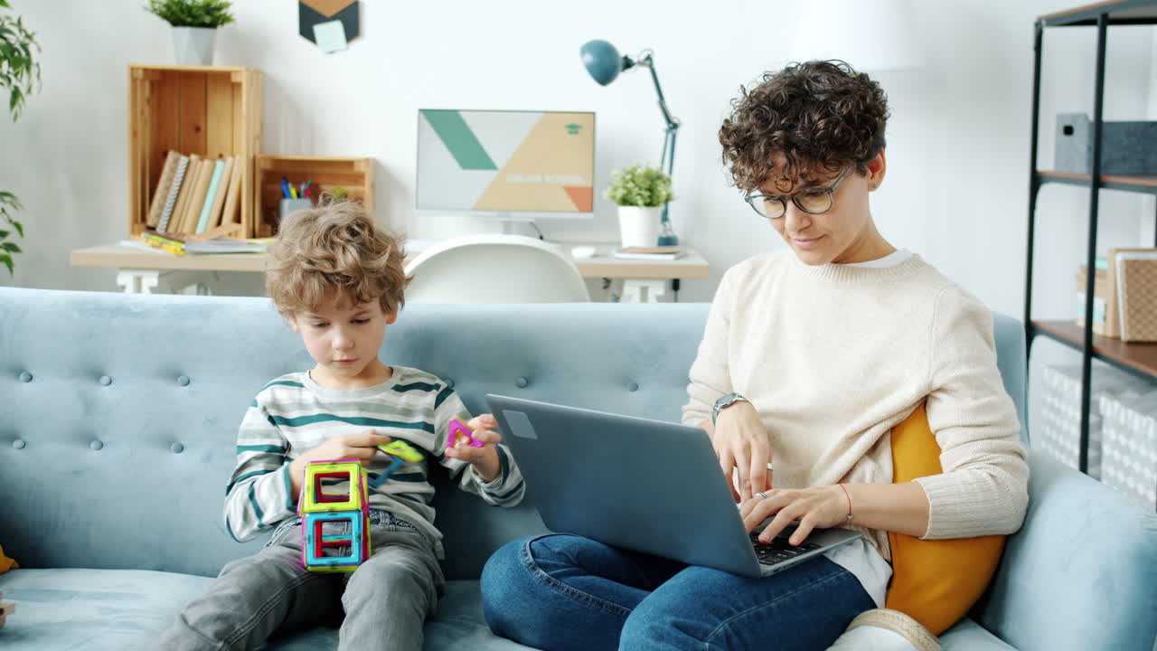 Mother working from home while child plays