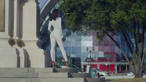 Vestida-Con-Un-Mono-Blanco,-Una-Joven-Saborea-Un-Día-En-La-Ciudad-Con-Napa-De-Fondo