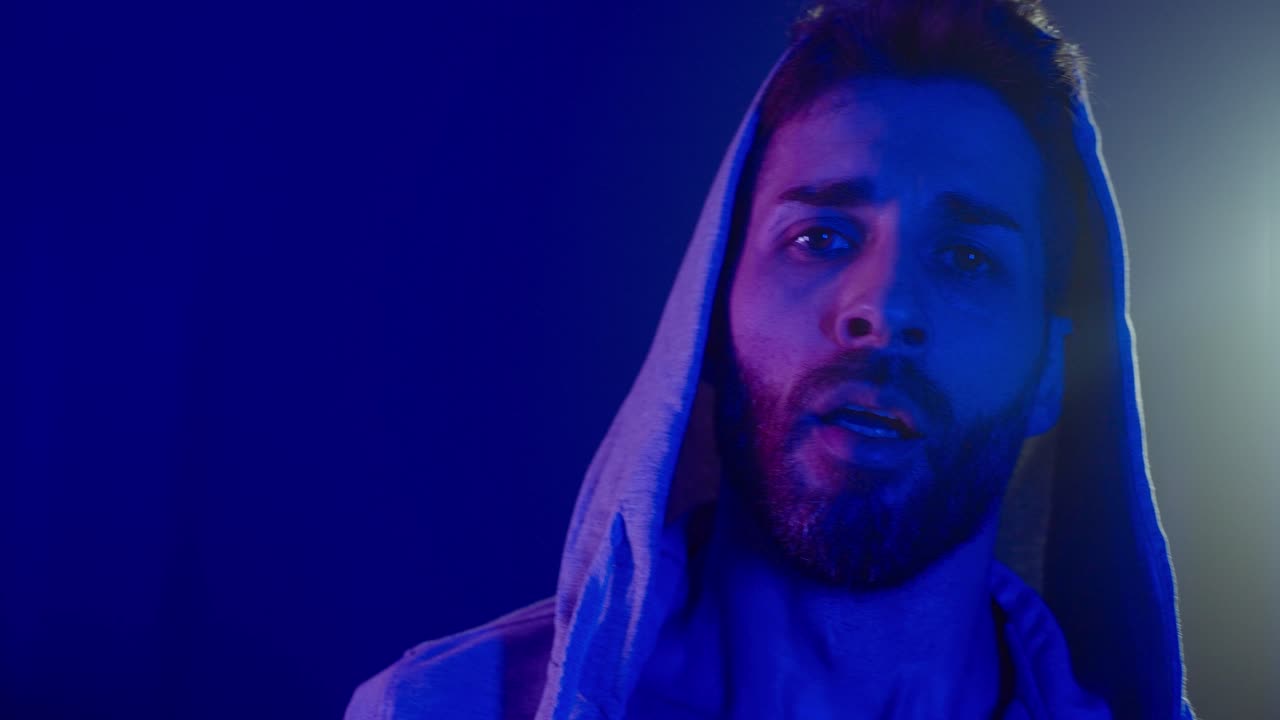 Uomo con felpa con cappuccio e luce blu