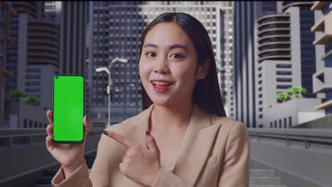 초록색 화면 을 가진 스마트폰 을 들고 있는 사업가