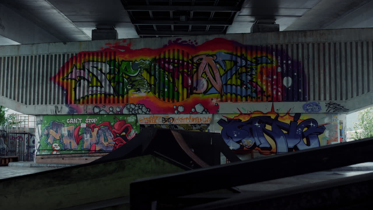 Skatepark senza persone, con graffiti colorati sul muro. Rampa vuota dello skatepark.