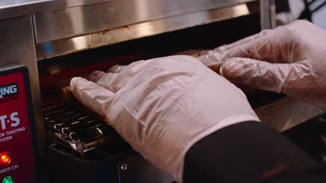 putting bread in toaster for sandwich preparation and making, close up