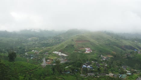 remote village hatton surrounded by lush green mountains with thick mist