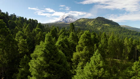 strzał z drona przecinający las przed wulkanem popocatepetl w meksyku podczas emisji fumaroli