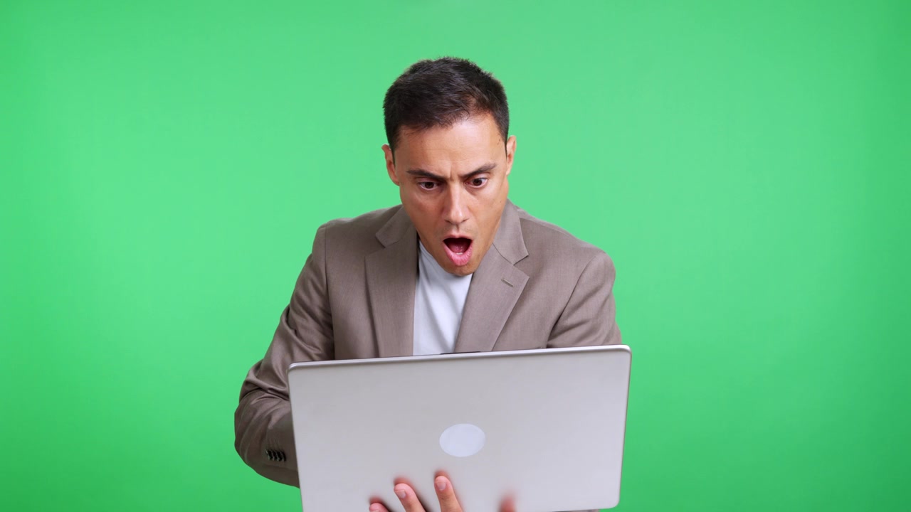 Businessman looking stressed and shocked using a laptop