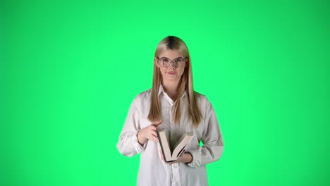 Young-Blonde-Woman-Reading-a-Book-Then-Looking-At-Camera,-Studio-Shot-With-Green-Background