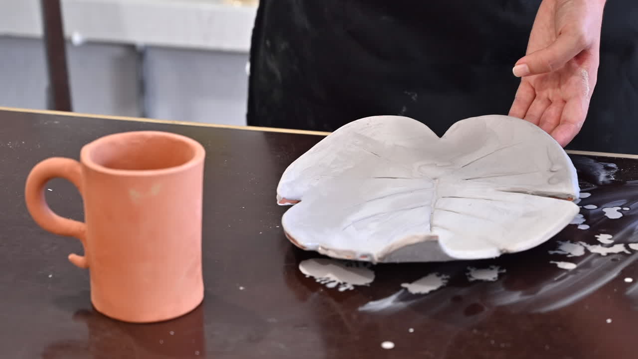Mulher pintando um prato de folha com branco