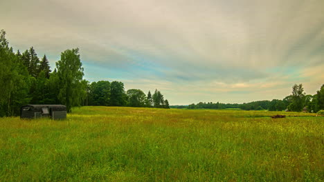 sunset time lapse of a tiny home in an open grassland field near a forest